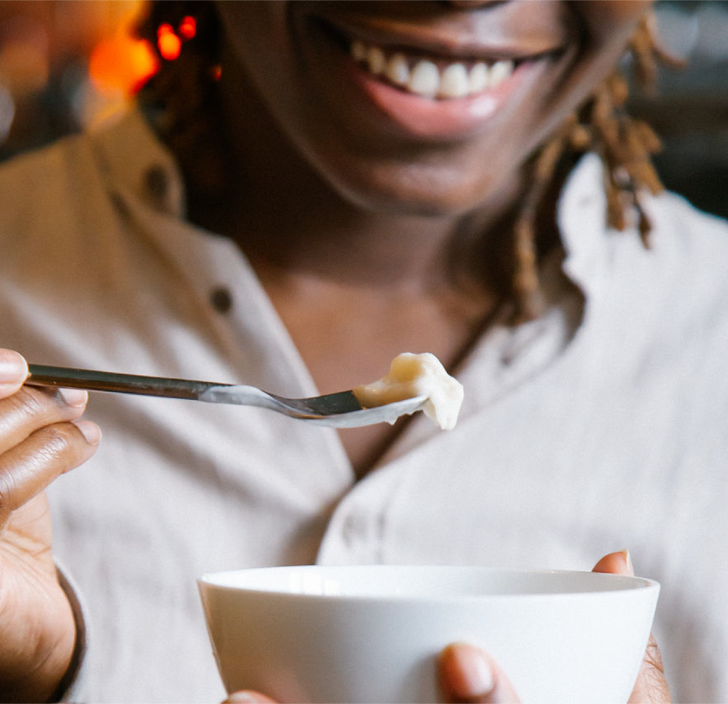 Person holding a spoon up of Mama Dolce's dairy free Banana and Lime, they are smiling anticipating the burst of flavour