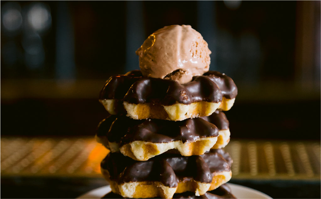 Scoop of Mama Dolce's dairy free chocolate indulgence on top of chocolate dipped waffles
